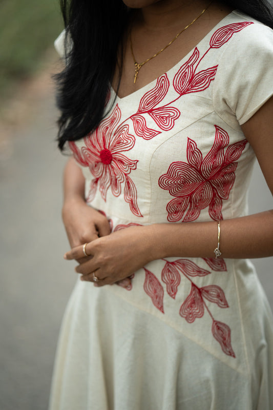 Serene in off white with red hand embroidery showing umbrella frock with special yoke pattern and design