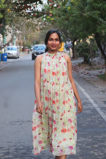 Jaselle in pastel mint with vibrant floral prints showing pleated halter neck flared dress and design