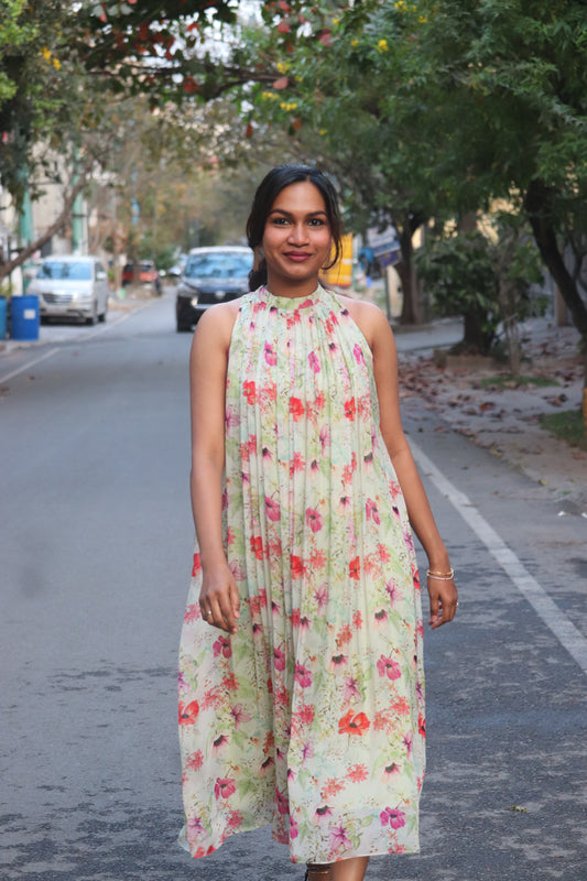 Jaselle in pastel mint with vibrant floral prints showing pleated halter neck flared dress and design