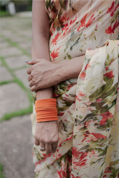 Close-up detail of Elaria saree showing orange digital floral print on light yellow organza fabric