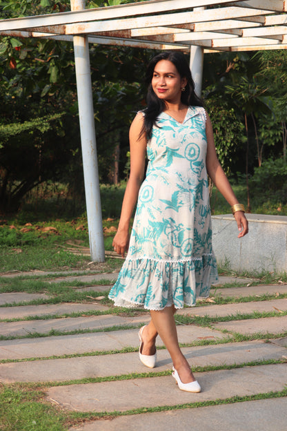 Woman wearing Petal linen dress in Aija Blue print walking outdoors under pergola structure