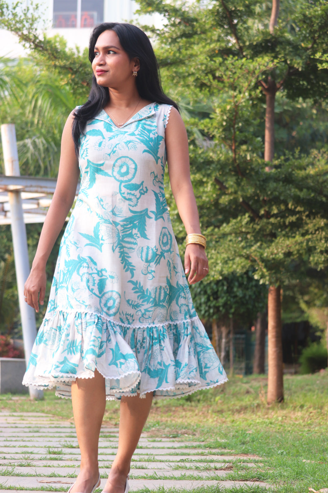 Woman in Petal linen dress with Aija Blue floral print showing silhouette and ruffled details in profile view