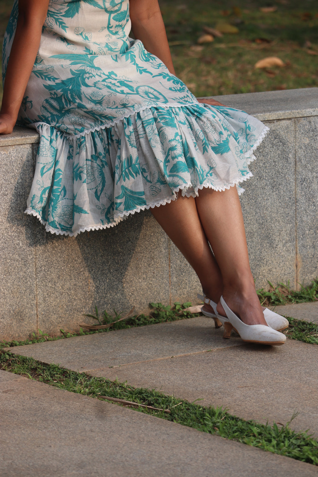 Close-up detail of Petal dress ruffled hem with lace edge and Aija Blue floral print on linen fabric