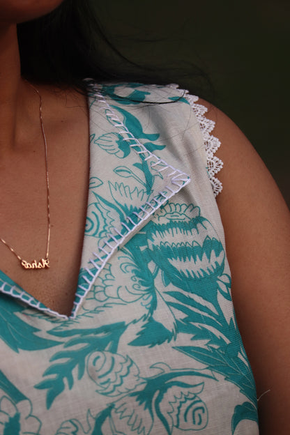 Close-up detail of Petal dress showing V-neckline, lace trim and Aija Blue floral print on linen