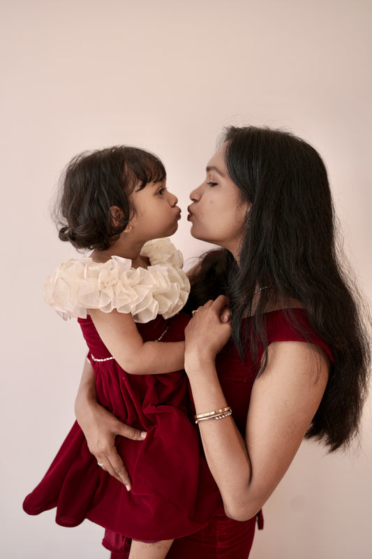 Mom wearing red velvet off-shoulder mermaid dress with crisscross tie-back