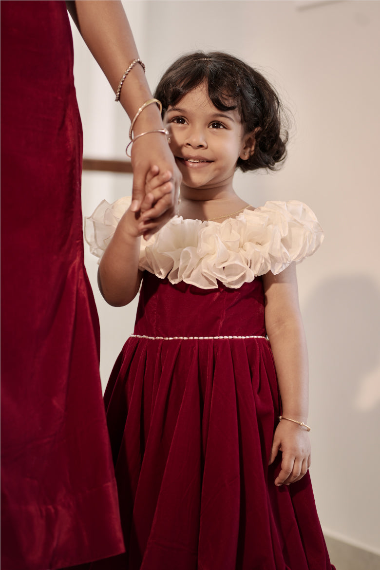Daughter wearing red and white off-shoulder umbrella dress with ruffle neckline