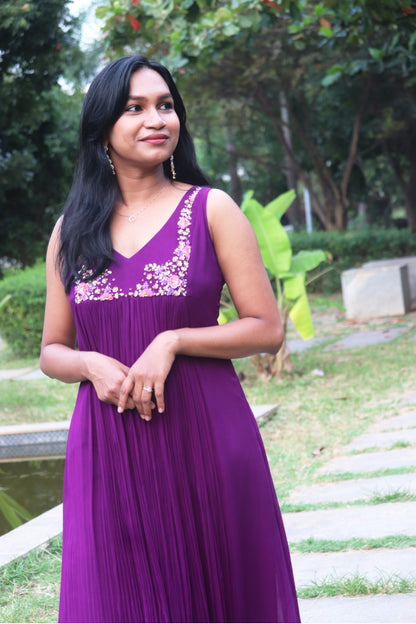 Woman wearing Viola dark purple viscose georgette kurti with handwork embroidery on the yoke, standing outdoors with greenery in background