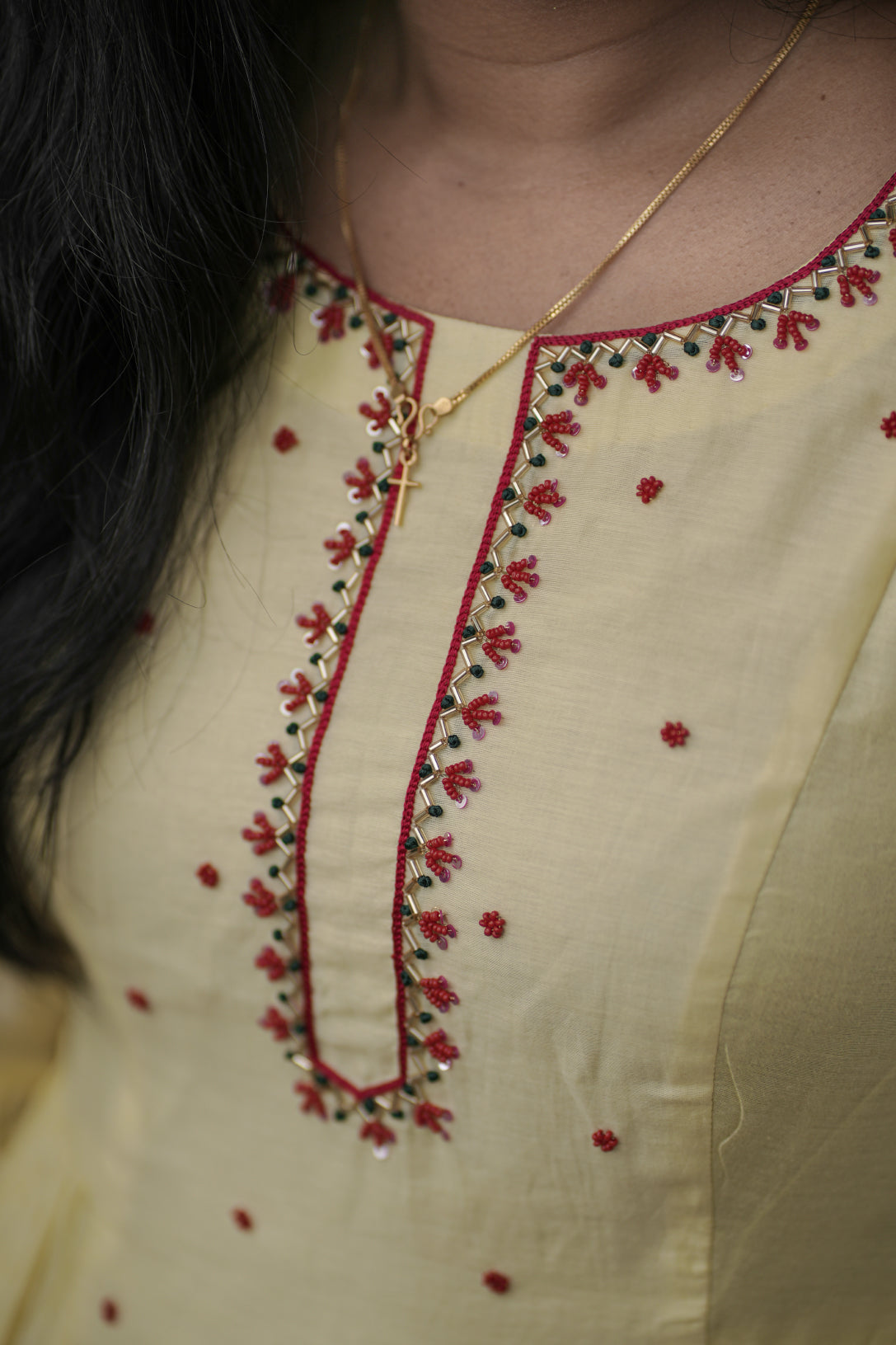 Sunhera close-up of red handwork details on neck and center panel detailing